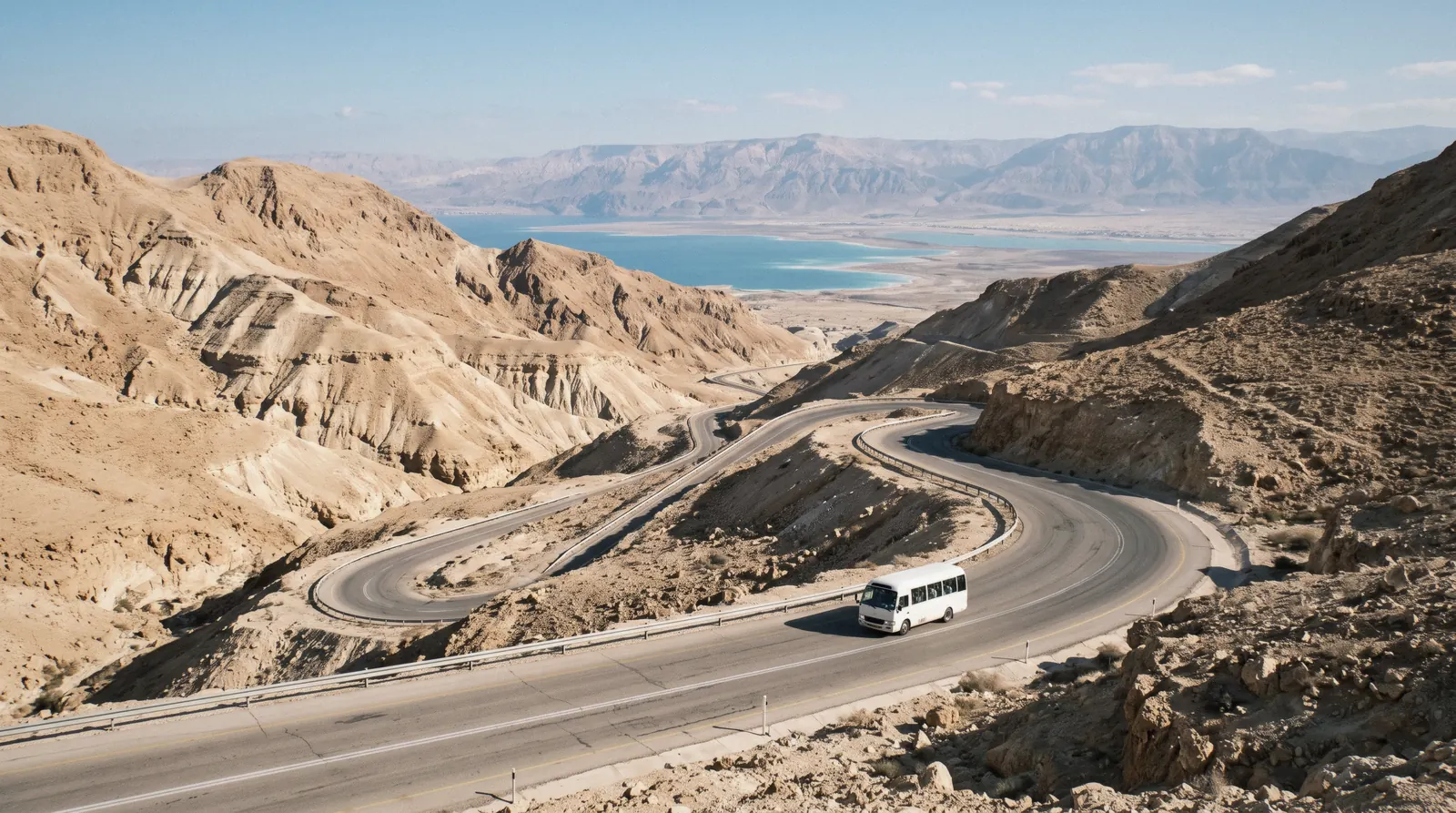 The road from Jerusalem descending through the bare tan hills of the Judean Desert toward the Dead Sea in early morning, day trips from jerusalem