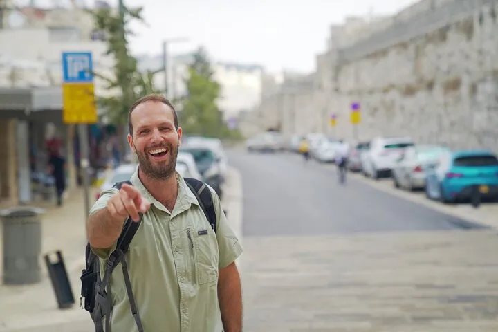 A private guide pointing out the Armenian Quarter walls to two travellers on a private Jerusalem tour